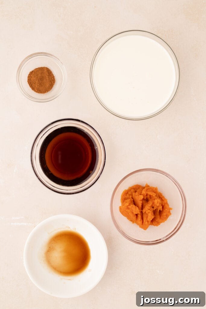 Overhead shot of all individual ingredients for homemade pumpkin spice creamer laid out in small bowls, including half and half, pumpkin puree, maple syrup, and spices.