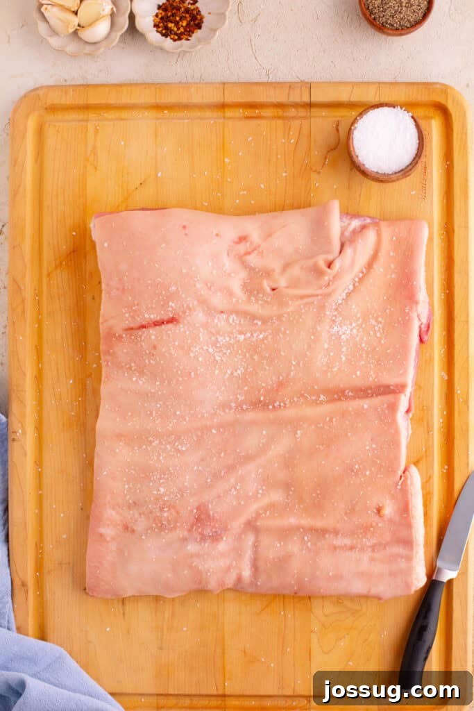 Crispy Porchetta Perfection 4 Pork belly on a cutting board lightly salted and ready to prep