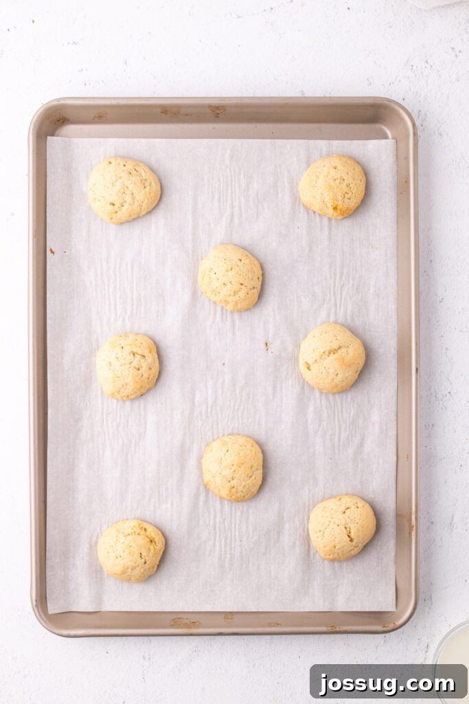 Pillowy Italian Ricotta Cookies 12 Freshly baked ricotta cookies cooling on a parchment-lined tray