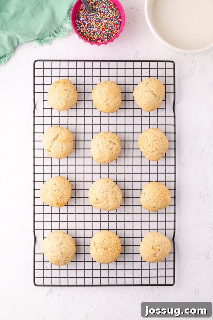 Pillowy Italian Ricotta Cookies 13 Baked ricotta cookies cooling on a wire rack with glaze and sprinkles nearby, preparing for the finishing touch