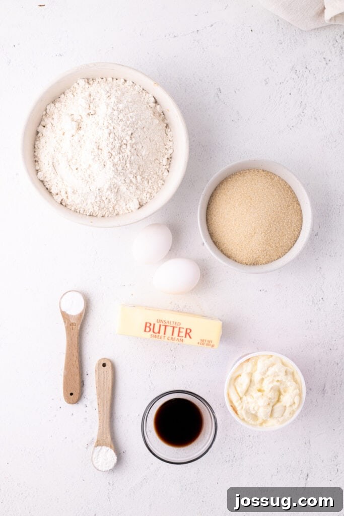 Pillowy Italian Ricotta Cookies 3 Overhead view of ingredients for Italian Ricotta Cookies arranged neatly on a white surface, including butter, sugar, eggs, ricotta, flour, and extracts