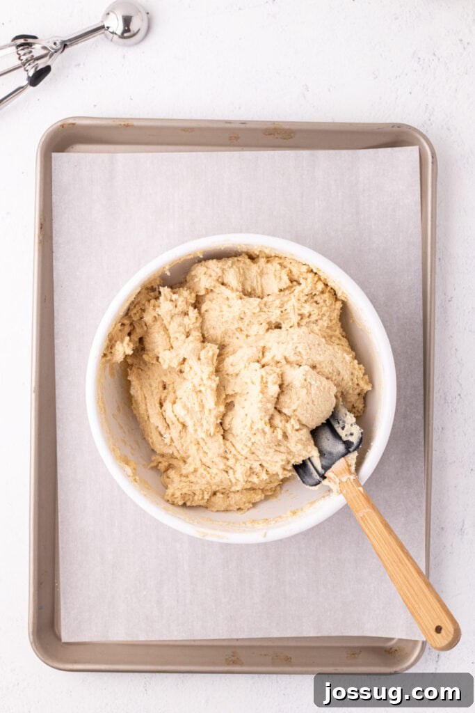 Pillowy Italian Ricotta Cookies 10 Finished, soft cookie dough in a mixing bowl with spatula ready to scoop