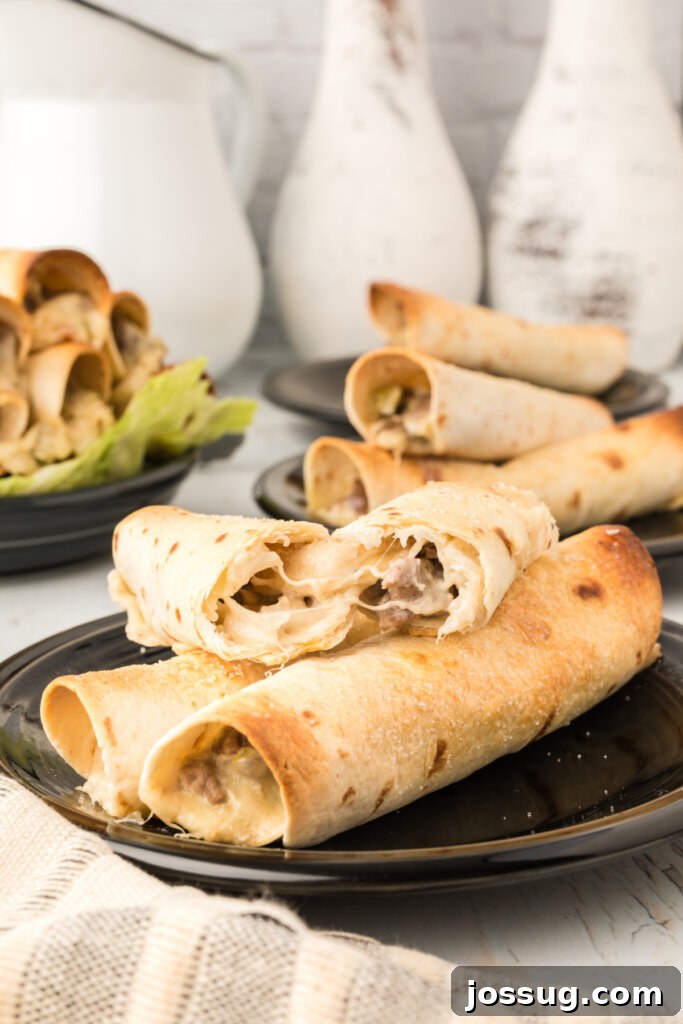 Crispy Philly Steak Rolls 5 Three golden-brown Philly Cheesesteak Taquitos presented on a white serving plate