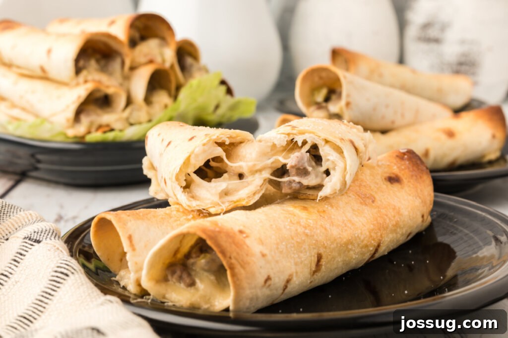 Crispy Philly Steak Rolls 6 A generous serving of crispy Philly Cheesesteak Taquitos on a black plate, artfully arranged