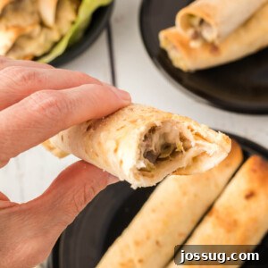 Philly Cheesesteak Taquito, bitten to show filling, on a cutting board