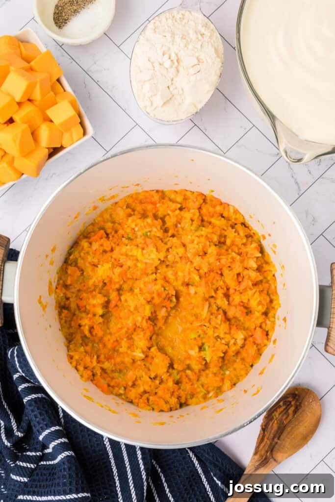 The pureed vegetables are gently sweating in the butter within the pot, softening and releasing their natural colors and aromas, creating a fragrant foundation for the creamy cheese soup.
