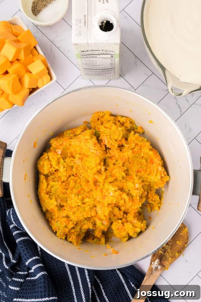 After thorough stirring, the vegetables and flour have combined to form a smooth, thick roux—a crucial base mixture for developing the creamy consistency and rich flavor of the cheese soup.