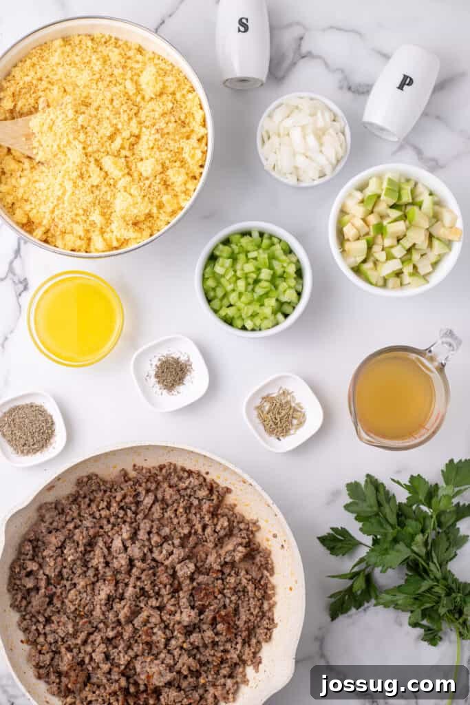 Homestyle Cornbread Dressing 4 Top down image of crumbled cornbread in a large bowl surrounded by cooked sausage, chopped veggies, herbs, melted butter, and broth.