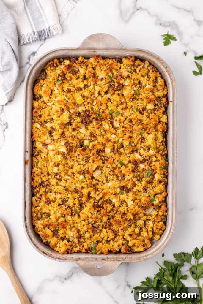 Homestyle Cornbread Dressing 10 Overhead view of baked cornbread dressing with a golden brown top inside a metal baking dish.