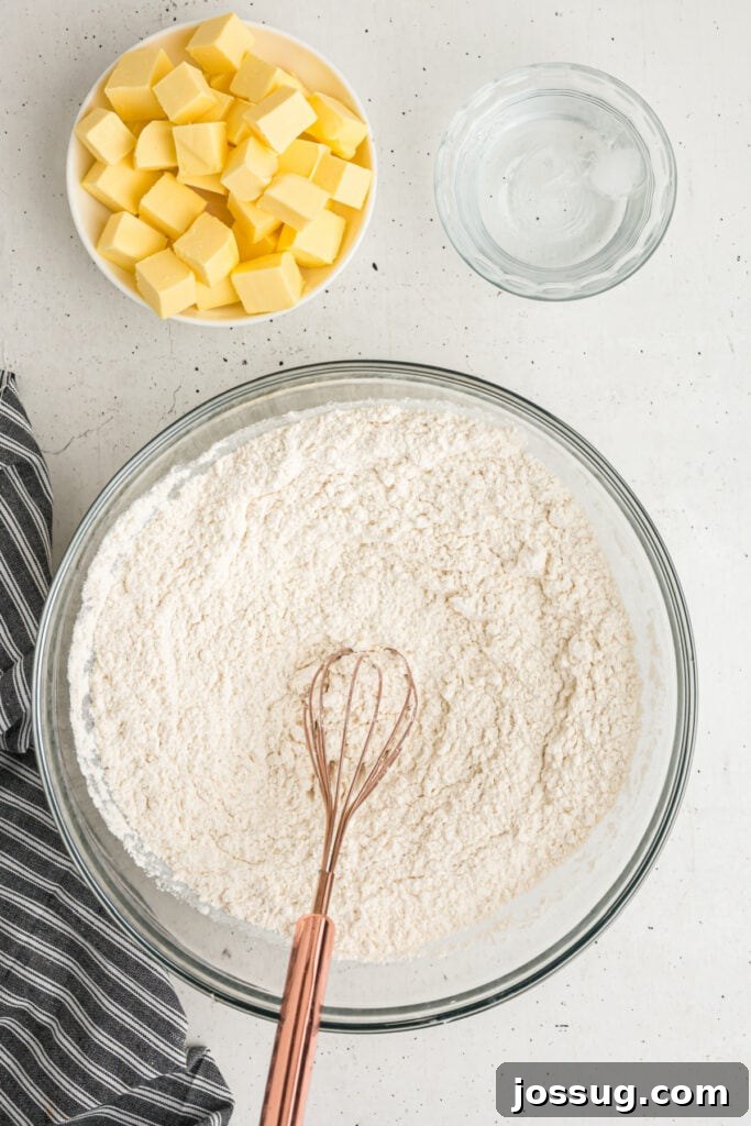 Whisk mixing dry ingredients in a large glass bowl for homemade pie crust