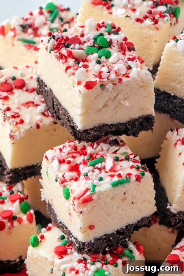 Several pieces of white chocolate peppermint fudge stacked artfully, showcasing the delightful layers and toppings.