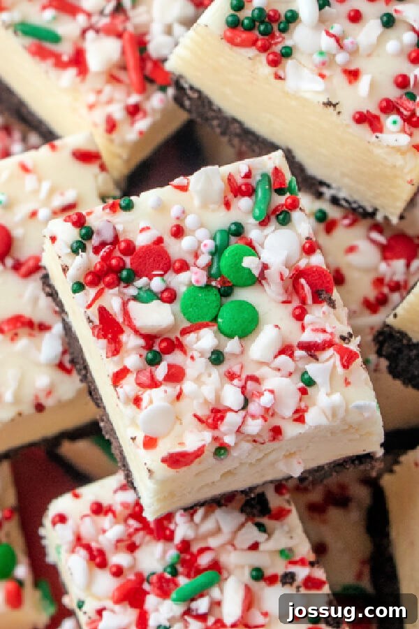A close-up shot of several fudge pieces stacked on a plate, highlighting their creamy texture and vibrant toppings.