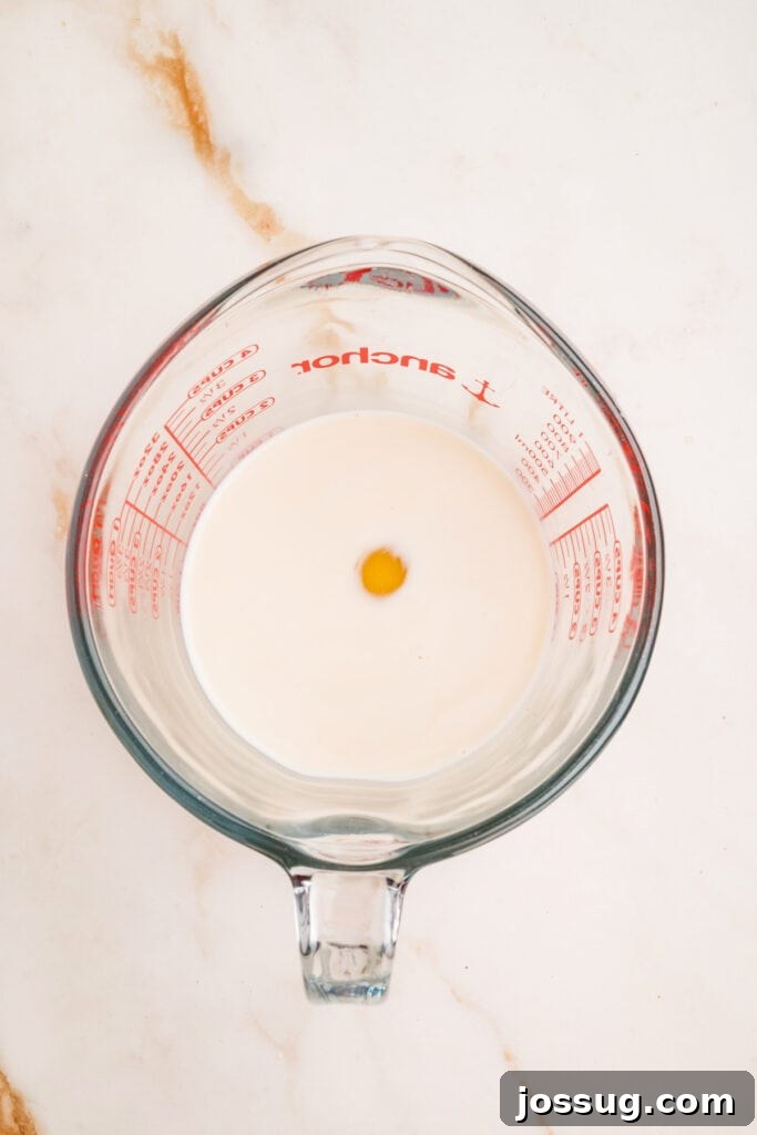Milk, egg, and vanilla in a glass measuring cup before mixing