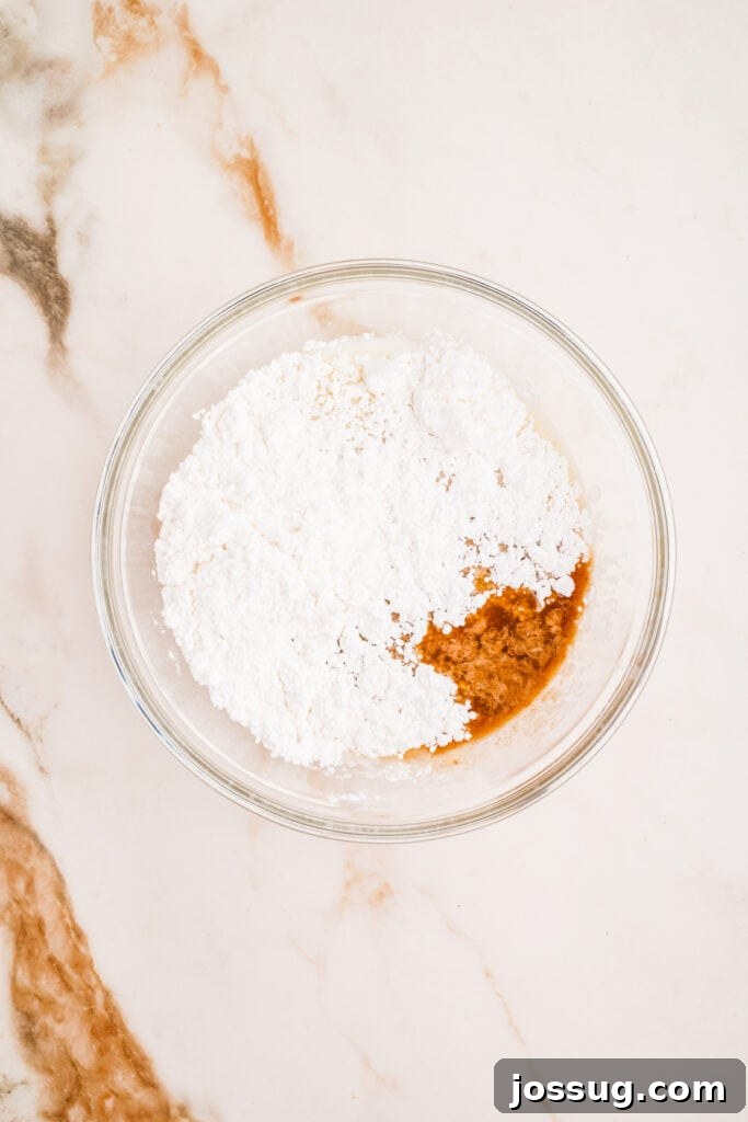 Glaze ingredients including powdered sugar and vanilla in a mixing bowl