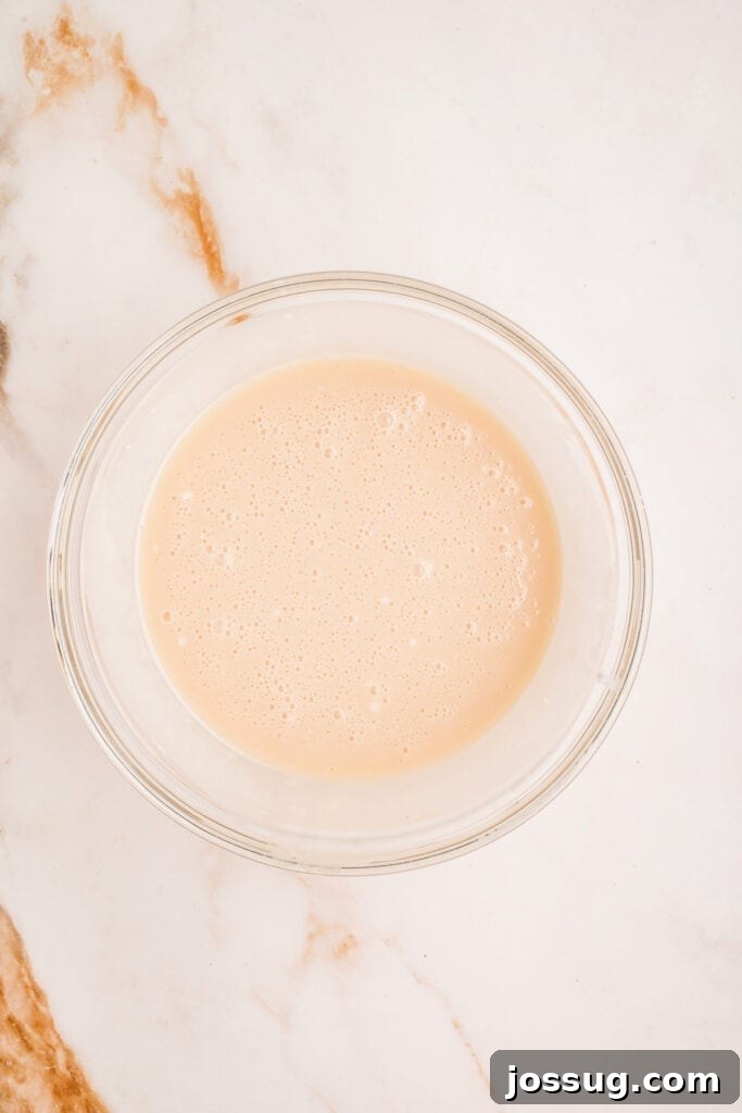 Smooth vanilla glaze mixed and ready in a glass bowl