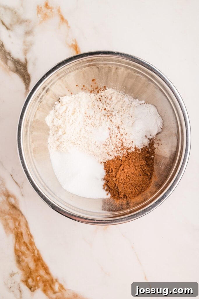 Dry ingredients for chocolate donut holes in a metal mixing bowl