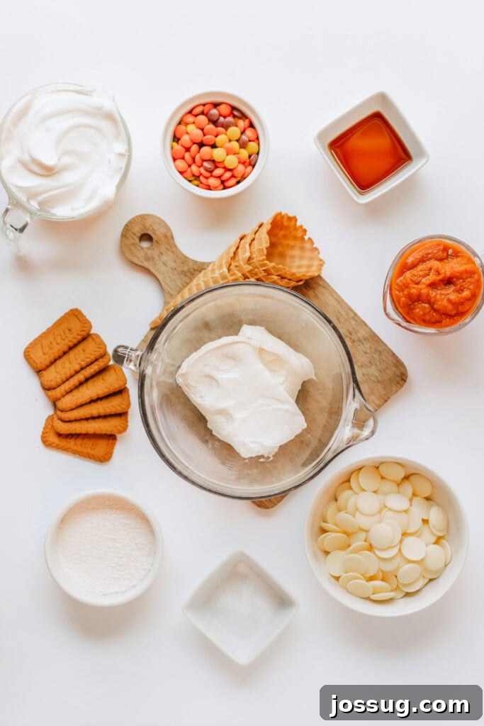 Overhead shot of all ingredients laid out including cream cheese, candy melts, pumpkin mix, and waffle cones, ready for assembly.
