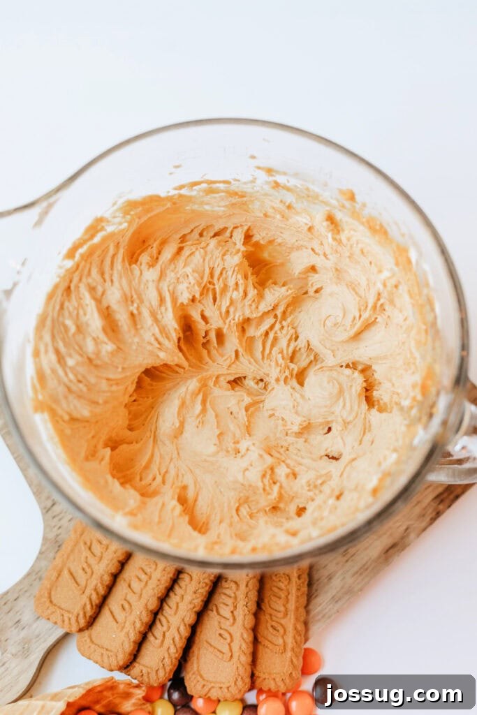 Cream cheese mixture fully blended with a rich pumpkin color and creamy texture, showing the smooth consistency of the cheesecake base.