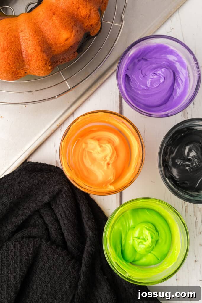 Bewitched Bundt Cake 20 Bowls of tinted frosting in orange, purple, green, and black next to cooled bundt cake.
