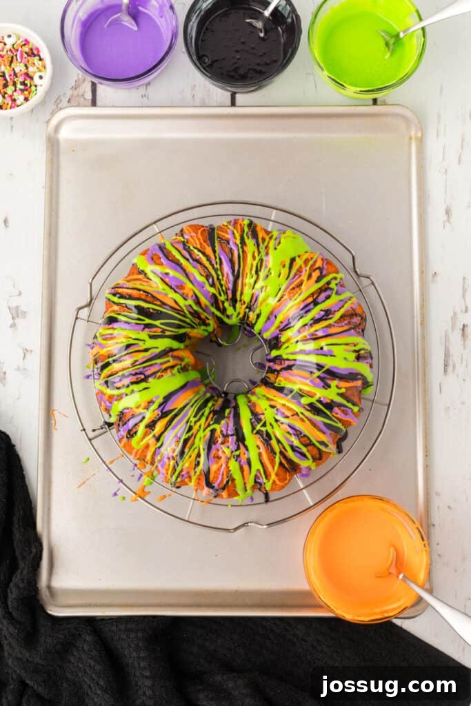 Bewitched Bundt Cake 22 Finished Halloween Bundt Cake drizzled with orange, purple, green, and black frosting stripes for a festive design.