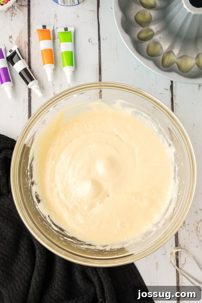 Bewitched Bundt Cake 5 Mixing bowl filled with white cake batter ready to be divided and tinted with Halloween food coloring.
