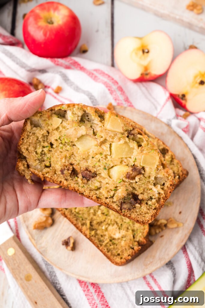 Spiced Apple Zucchini Bread 2 hand holding a slice of apple zucchini bread