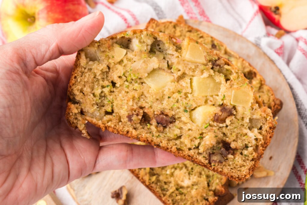 Spiced Apple Zucchini Bread 6 hand holding slice of apple zucchini bread