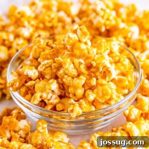 Close-up of a glass bowl filled with perfectly golden and glossy caramel corn, showcasing its inviting crunch and delightful texture.