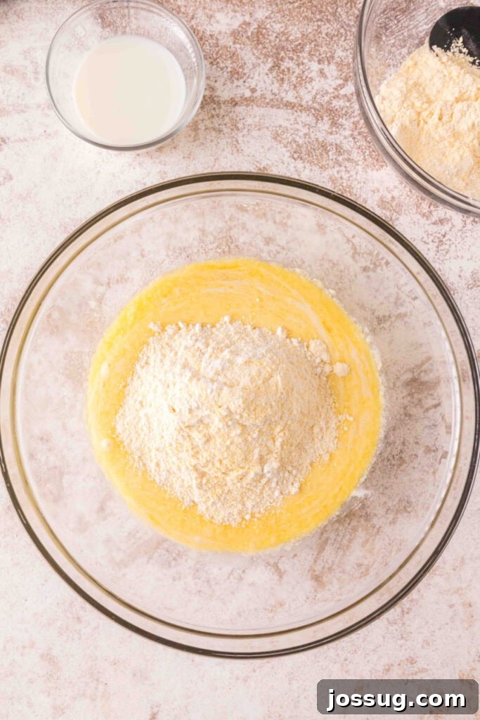 Cultured Cornbread 10 Bowl of wet cornbread batter with dry flour and cornmeal mixture poured on top.