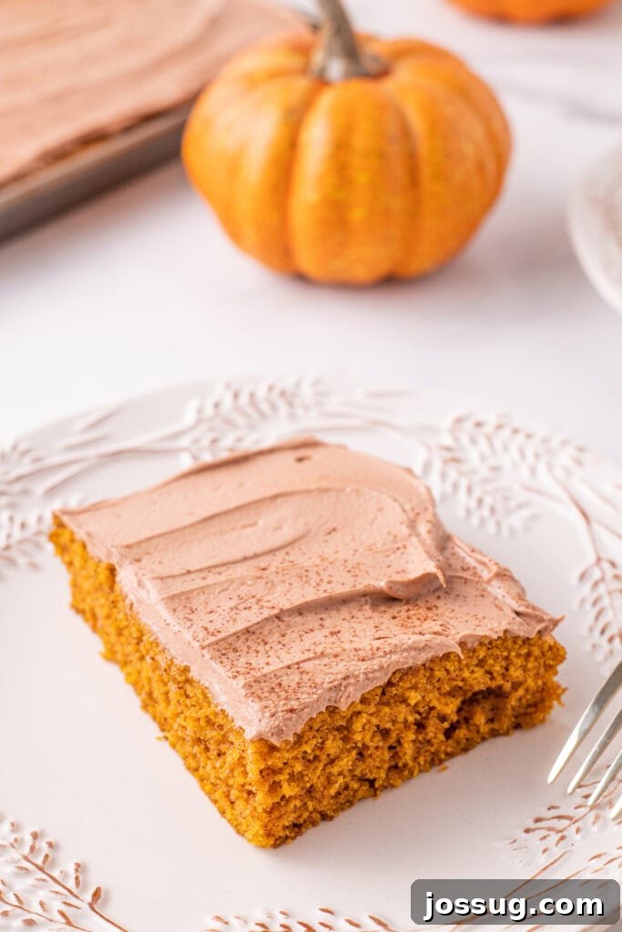 Golden Pumpkin Squares 2 A perfectly sliced pumpkin bar on a plate, showcasing its moist texture and a generous layer of fluffy Nutella buttercream frosting, with miniature pumpkins in the softly blurred background evoking a cozy fall atmosphere.