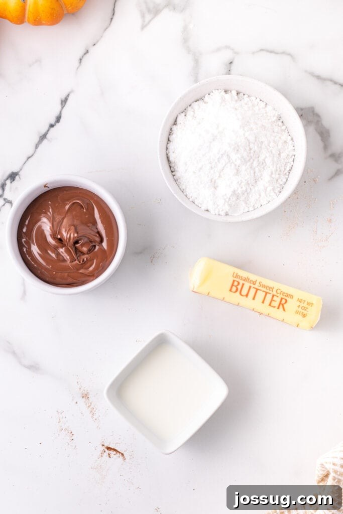 Golden Pumpkin Squares 4 Carefully arranged ingredients for the rich Nutella buttercream frosting on a marble surface, featuring softened butter, a jar of Nutella, powdered sugar, and a small jug of milk, all prepped for whisking.