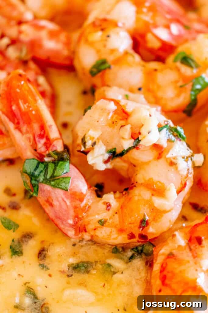 Succulent Air Fryer Garlic Butter Shrimp 2 Extreme close-up of succulent shrimp glistening with a rich garlic butter sauce, beautifully garnished with fresh green parsley and visible pieces of aromatic minced garlic.