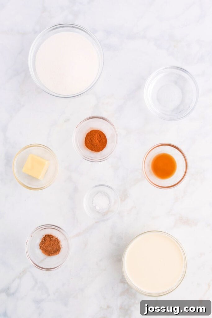 Ingredients for spiced caramel sauce, including sugar, heavy cream, butter, vanilla extract, and various spices, beautifully arranged on a kitchen counter.