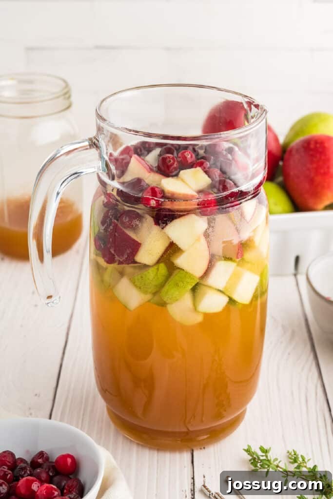 Autumn Orchard Sangria 5 Pitcher filled with chopped fruit, apple cider, and white wine for making apple cider sangria