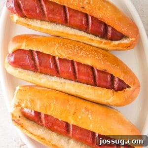 Square-cropped image of hot dogs in toasted buns ready to serve