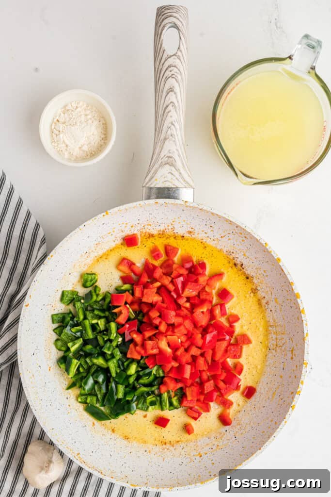 Fiesta Chicken Fettuccine Alfredo 6 Diced poblano and red bell peppers freshly added to the same hot skillet with residual butter and chicken juices.