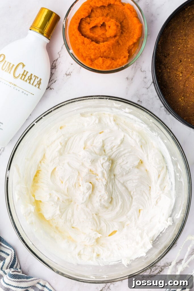 Decadent No-Bake RumChata Pumpkin Cheesecake 11 Smooth and fluffy cheesecake base mixture after folding in cool whip, with pumpkin puree and RumChata nearby.