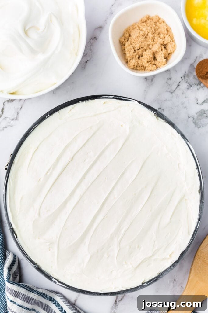 Decadent No-Bake RumChata Pumpkin Cheesecake 15 RumChata cheesecake layer smoothed over the chilled pumpkin layer in the springform pan, creating two distinct layers.