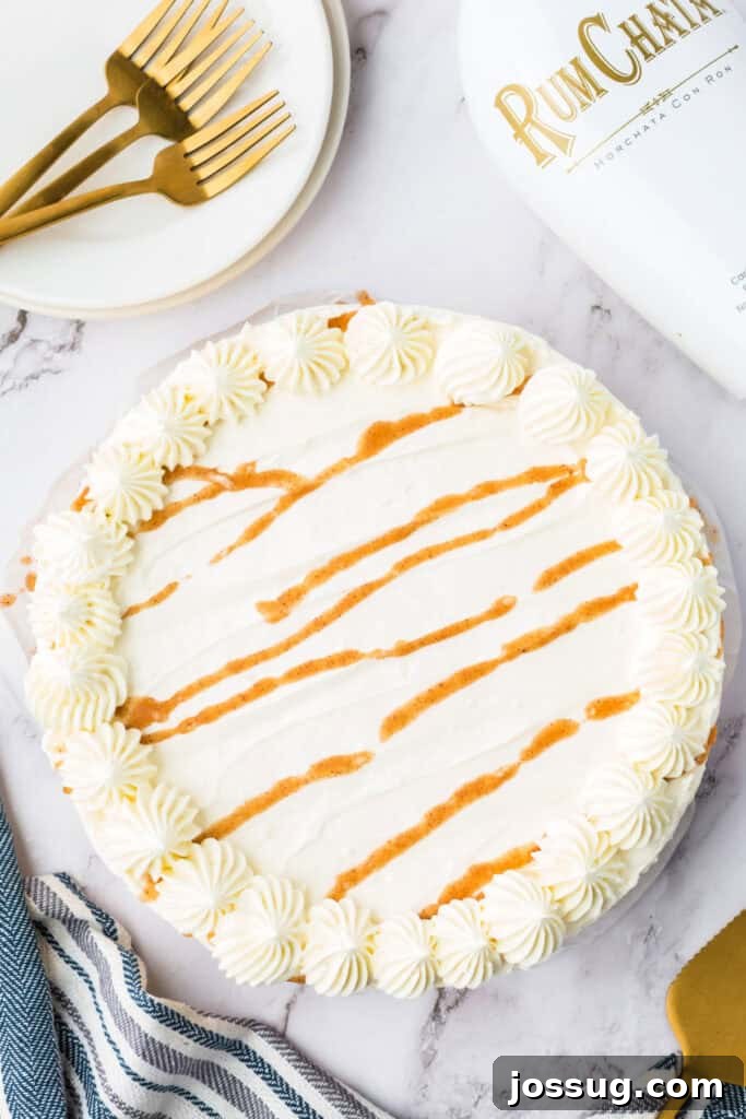 Decadent No-Bake RumChata Pumpkin Cheesecake 18 Overhead view of the finished no bake RumChata pumpkin cheesecake topped with piped whipped cream swirls and cinnamon drizzle.