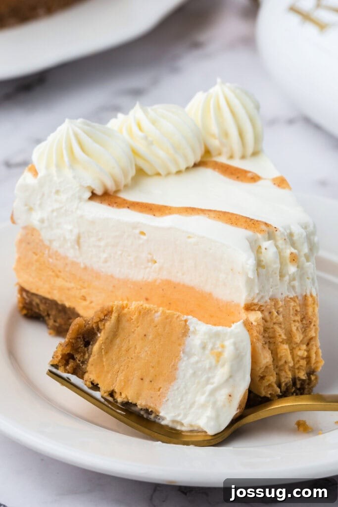 Decadent No-Bake RumChata Pumpkin Cheesecake 19 Close-up of a plated slice of no bake RumChata pumpkin cheesecake with a bite taken, showing creamy texture of both layers.