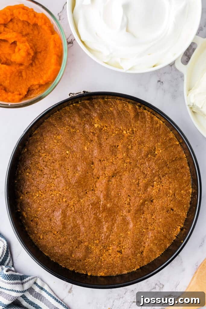 Decadent No-Bake RumChata Pumpkin Cheesecake 7 Smooth and evenly pressed graham cracker crust set in the springform pan, with pumpkin puree and cool whip bowls nearby.