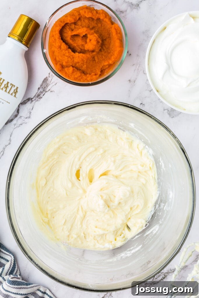 Decadent No-Bake RumChata Pumpkin Cheesecake 9 Cream cheese and powdered sugar mixture beaten smooth in a glass bowl, surrounded by pumpkin puree, RumChata, and cool whip.