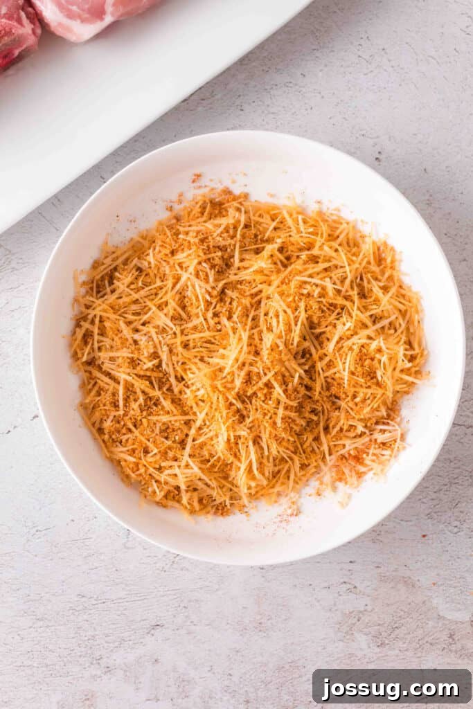 Golden Crispy Air Fried Bone In Pork Chops 9 Bowl of shredded Parmesan cheese mixed with seasoned crouton crumbs for pork chop coating.