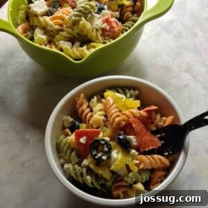 Zesty Pepperoni Feta Pasta Salad 2 Prepared Pepperoni & Feta Pasta Salad in a bowl, with a serving spoon.