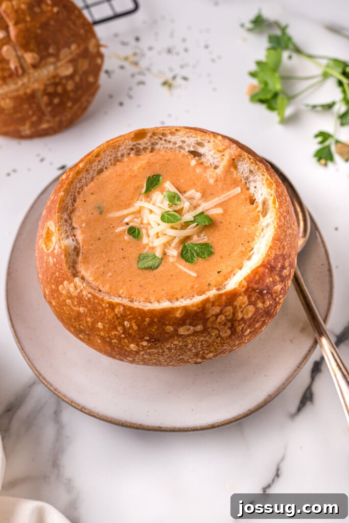 Creamy Slow Cooker Italian Parmesan Tomato Soup 4 A rustic homemade bread bowl generously filled with creamy tomato soup, ready to be enjoyed.
