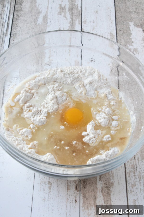 Wet ingredients being poured into the bowl of mixed dry ingredients for the coffee cake batter.