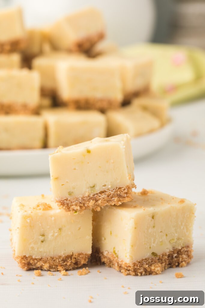 A vibrant green block of unset key lime pie fudge in a baking pan, garnished with fresh lime zest, ready for refrigeration