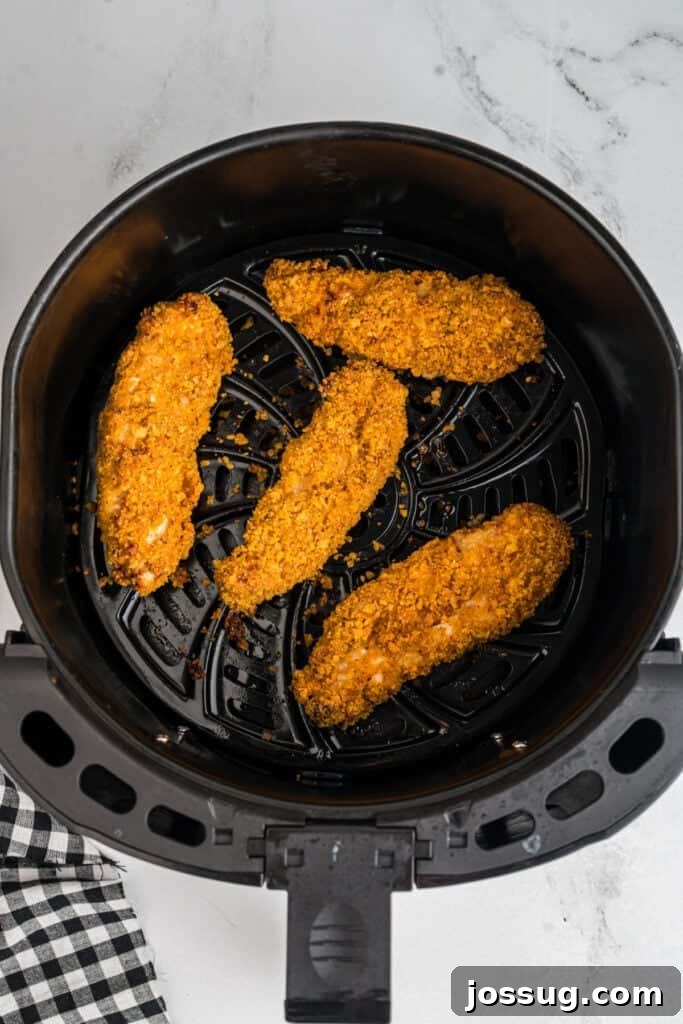 Golden-brown crispy cooked southwest chicken tenders perfectly air-fried, showcased in the air fryer basket after cooking.