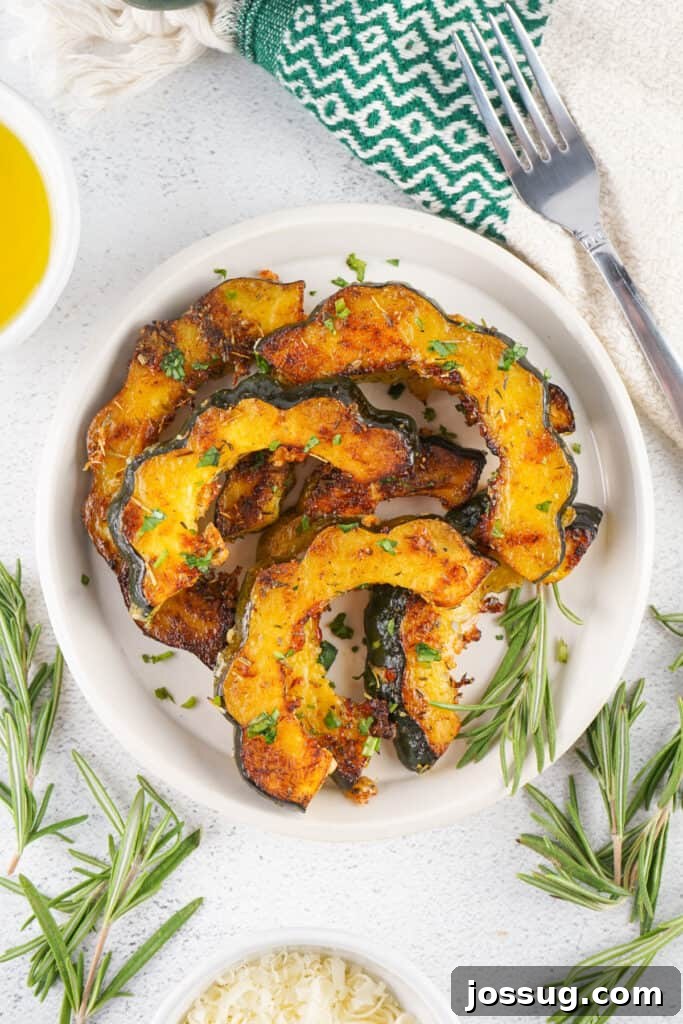 Caramelized Acorn Squash 11 Plate of roasted acorn squash slices arranged in a circle with rosemary sprigs and a fork.