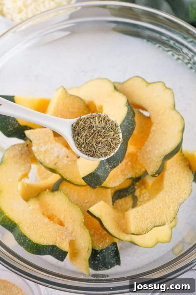Caramelized Acorn Squash 6 Spoonful of herbes de provence being added to sliced acorn squash in a mixing bowl.